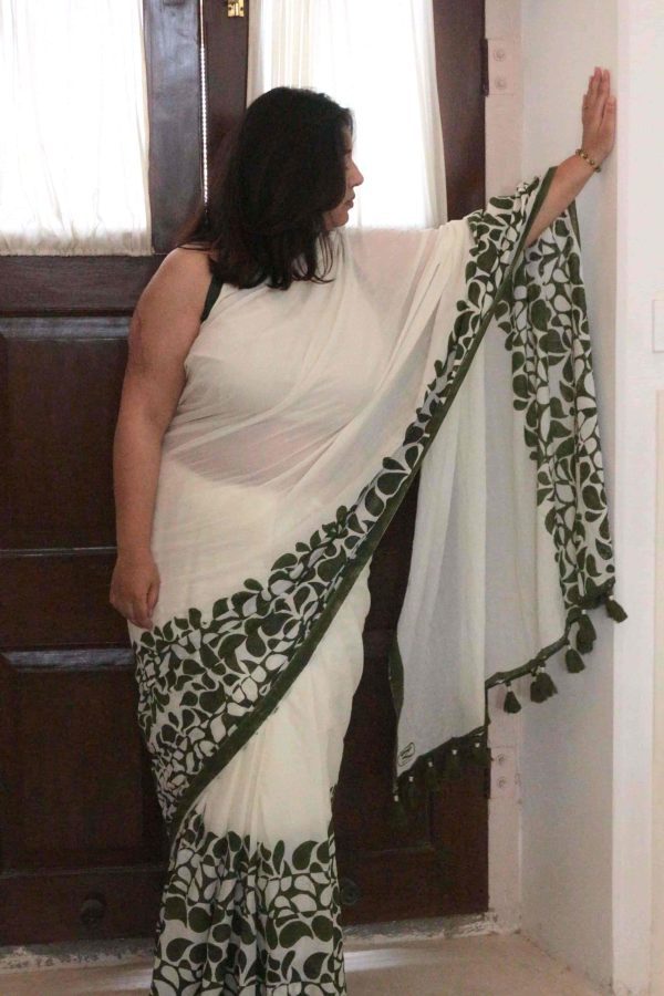 Baawri saree in moonwashed ivory cotton with green abstract drop motifs along the border, minimal green stripe, tassels, and matching blouse.