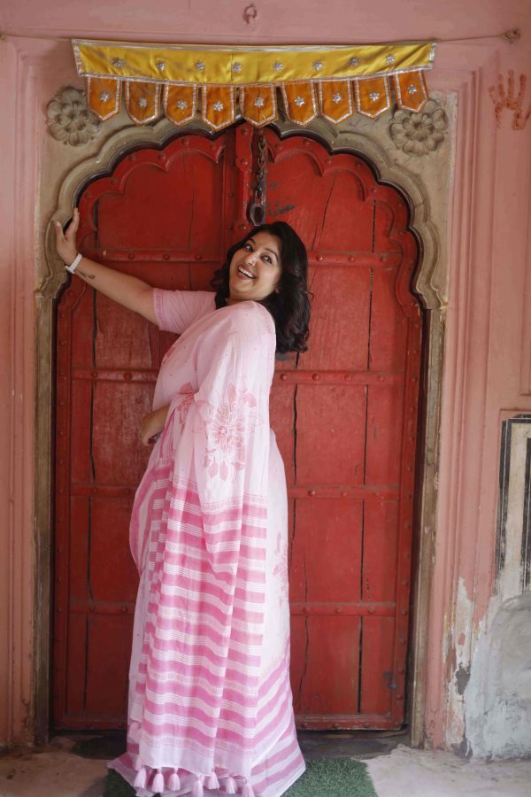 Gulabi Dhoop saree in blush pink cotton with floral motifs in pink shades, striped pallu, tassels, and matching blouse piece.
