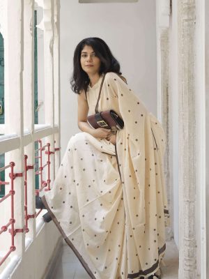 Melody Dots cotton saree in oat beige with hand-block printed dark brown polka dots, dark brown border, tassels on the pallu, and matching blouse fabric.