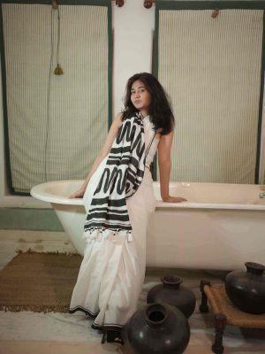 Aakhiri Panna white cotton saree with black abstract block-printed pallu, bold black border, tassels, and matching blouse piece.
