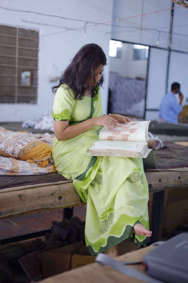 Mango Bagh saree in orchard green cotton with floral-filled mango motifs, wide wave border in dark and light green, tassels, and matching blouse piece.