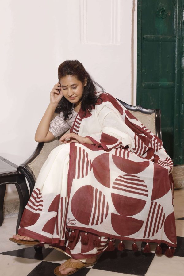 Silsila cotton saree in off-white with maroon semi-circle motifs, maroon striped border, tassels on the pallu, and matching blouse fabric.